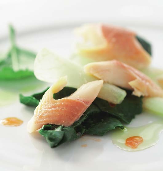 Tender salmon served over wilted spinach with glazed scallions