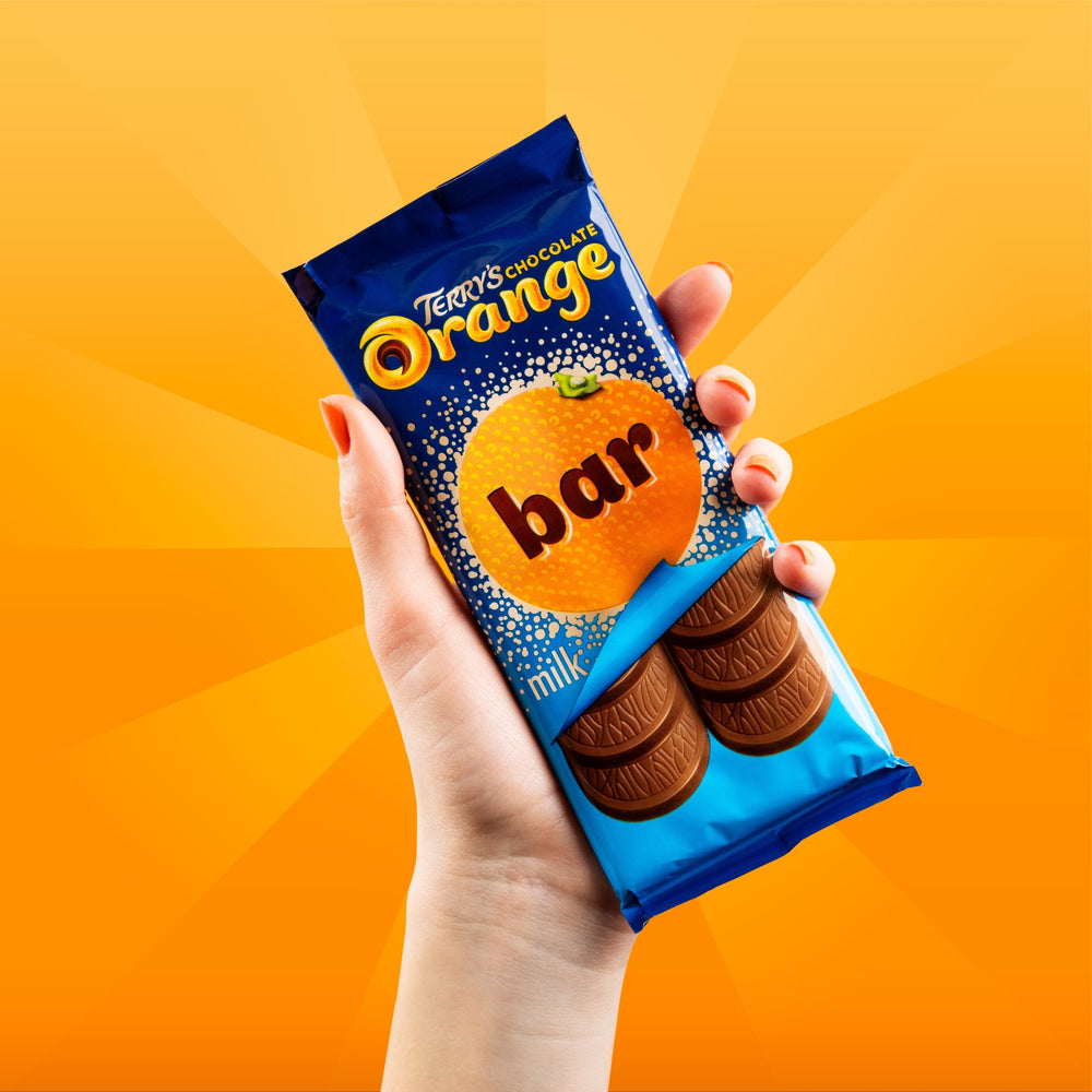 Terry's Milk Chocolate Orange Bar package held against an orange background