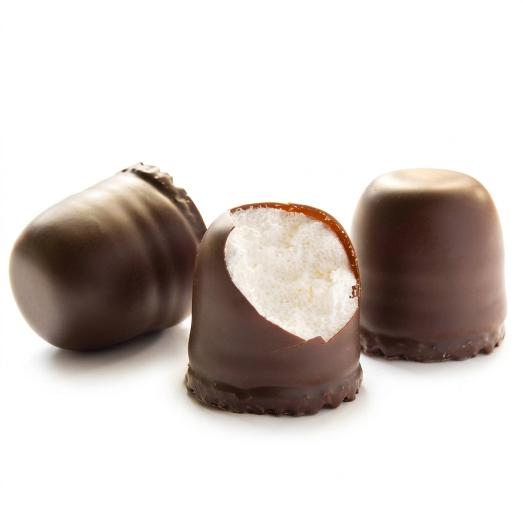 Three chocolate-covered confection pieces on a white background, with one piece broken open to show a white cream filling and a caramel-colored edge.