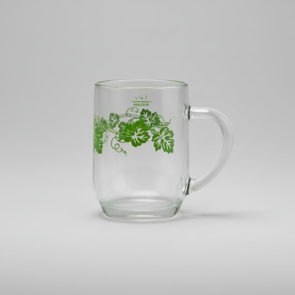 Clear glass mug with green leaf design on a wooden surface