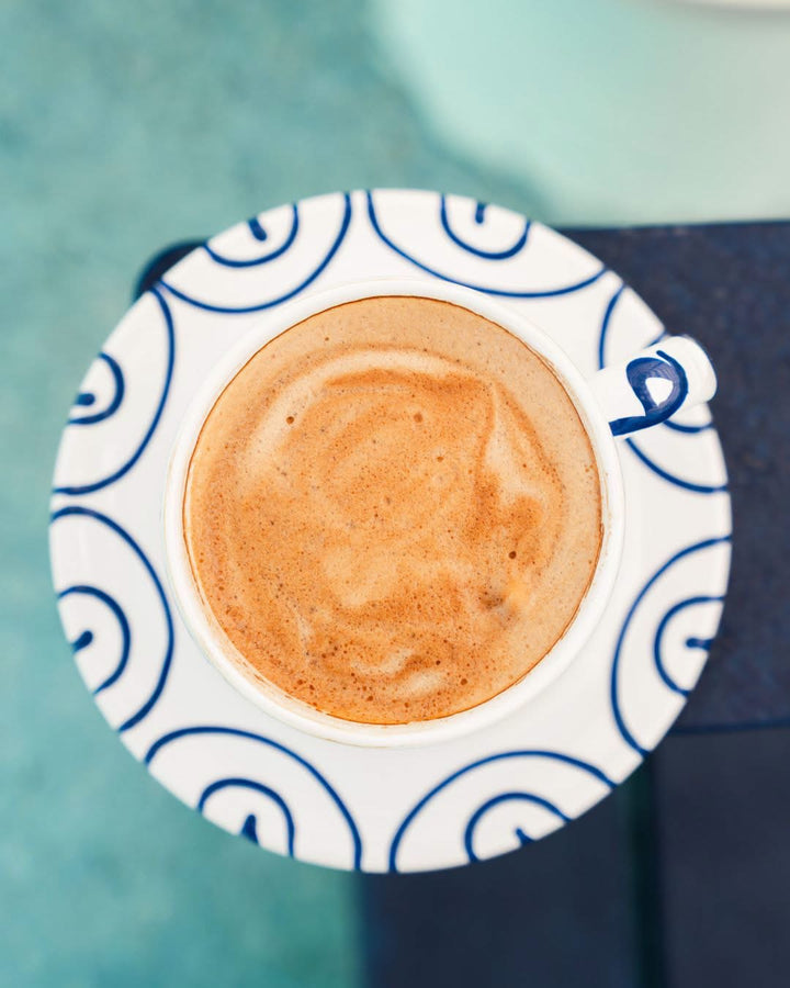 Overhead view of a blue flamed saucer with a cup of coffee; cup sold separately