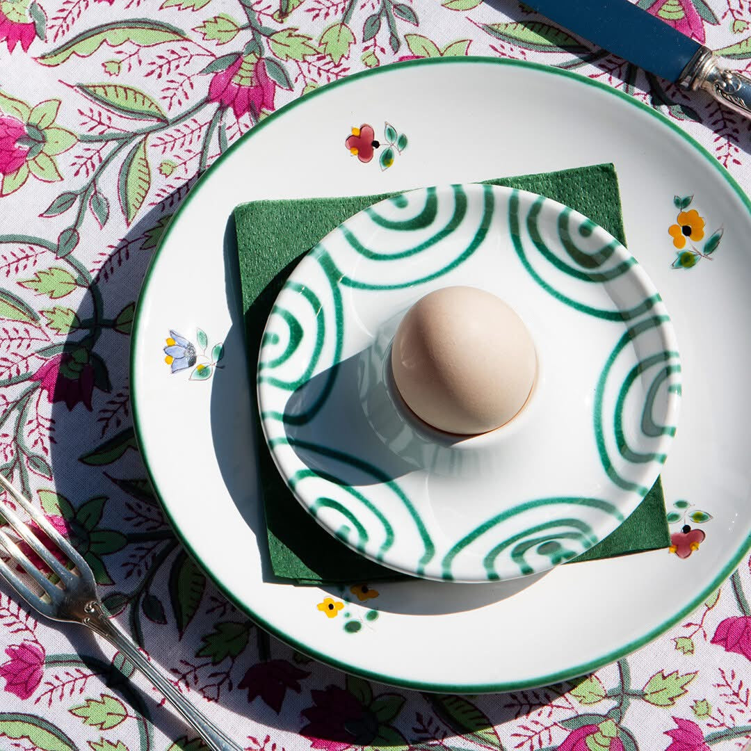 Green flamed and Alpine Flowers ceramic plates layered at a breakfast setting