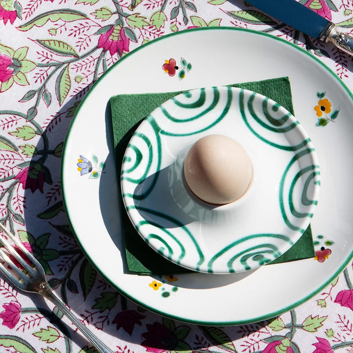 Green flamed and Alpine Flowers ceramic plates layered at a breakfast setting