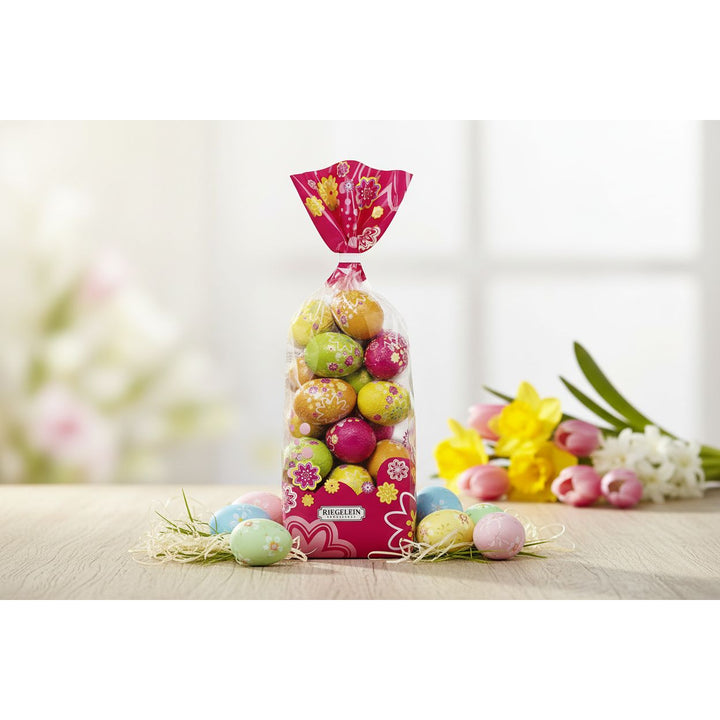 Bag of colorful Easter eggs with floral design on a white background